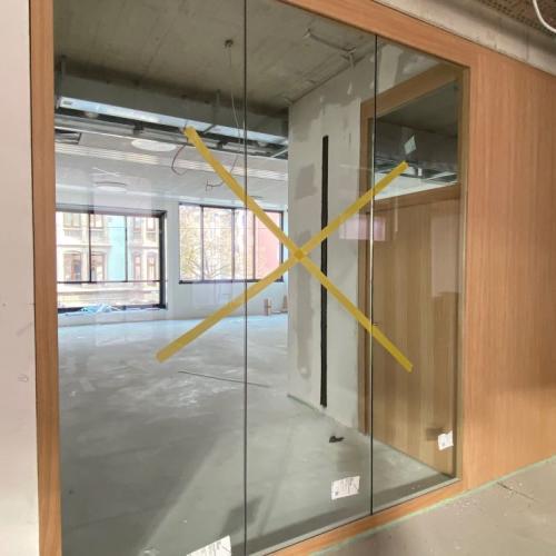 Blick in neuen Klassenraum mit Glaswand und Holztüren
