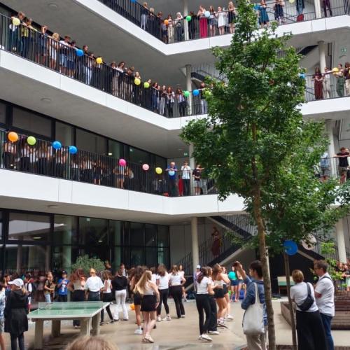 Schüler*innen in einem Schulhof mit Balkonen