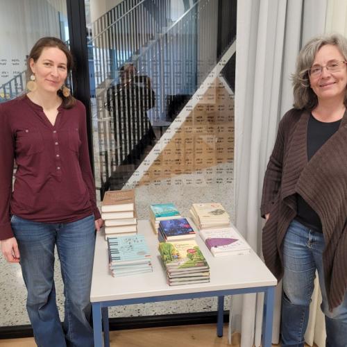 Zwei Frauen stehen neben einem Tisch mit Büchern