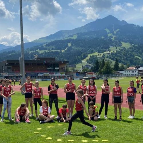 Kinder in roter Sportkleidung auf einem Sportplatz