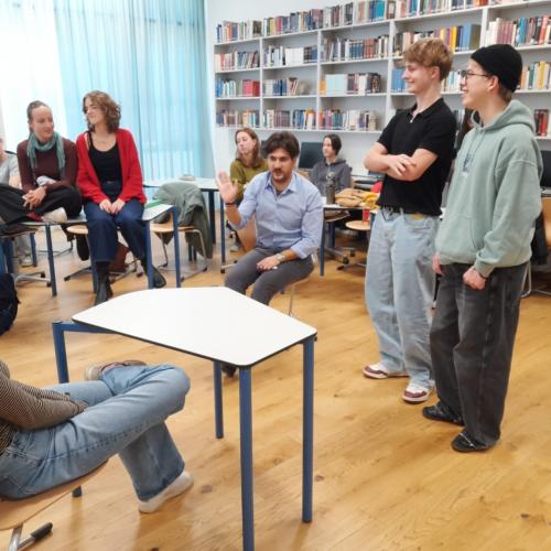 Schüler in der Bibliothek, sitzend und stehend