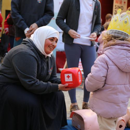 Junge Frau zeigt Erste-Hilfe-Würfel