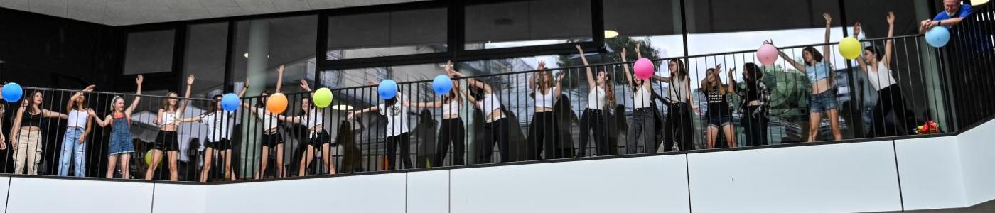 Schulhof und Balkone mit tanzenden Schüler:innen