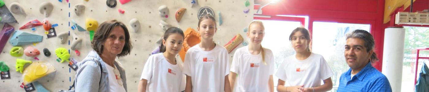 Vier Kinder und Lehrerin vor einer Kletterwand