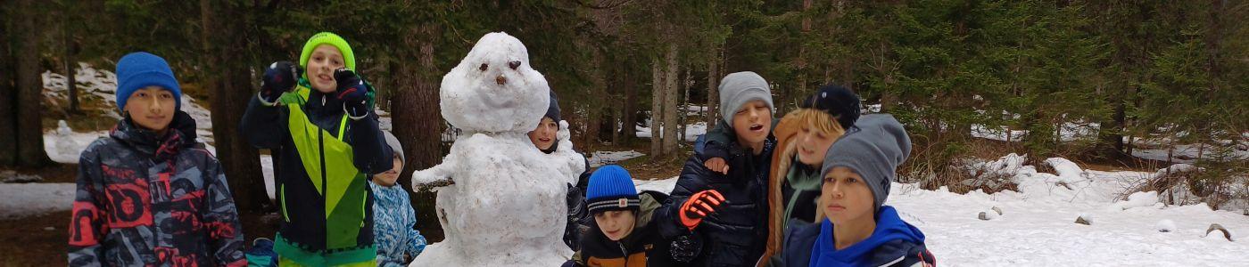Kinder mit Schneemann in der Mitte