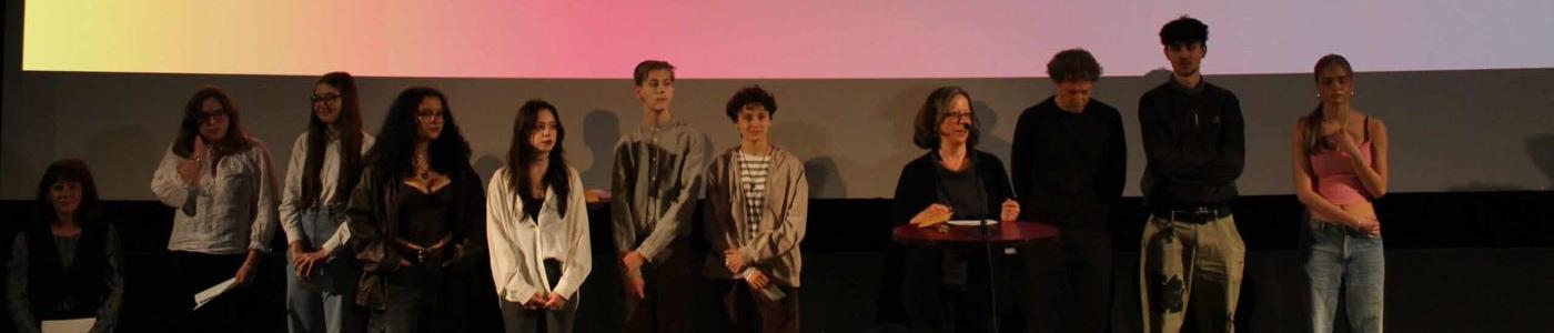 Schüler:innen vor einer Leinwand mit der Aufschrift "IFFI"