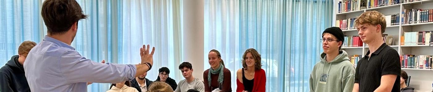 Schüler in der Bibliothek, sitzend und stehend