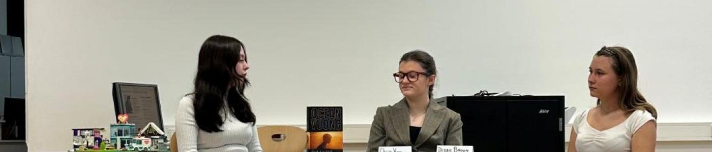 3 Schülerinnen diskutieren an einem Tisch