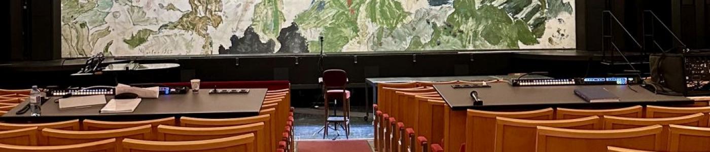 Stuhlreihen des Landestheaters mit Bild von Max Weiler