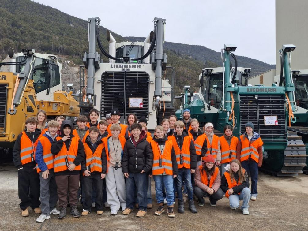 Schüler:innengruppe vor Planierraupen von Liebherr