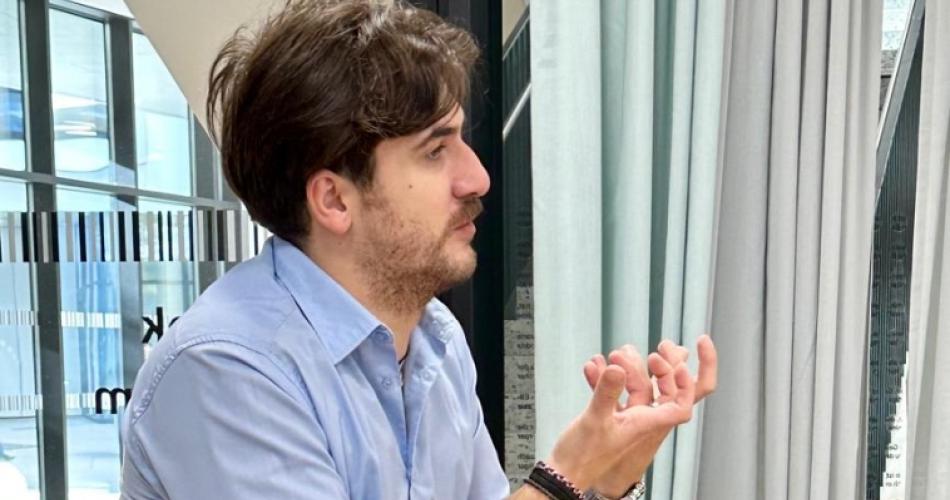 Der Autor Gigi Colasanto sitzt auf einem Tisch und gestikuliert