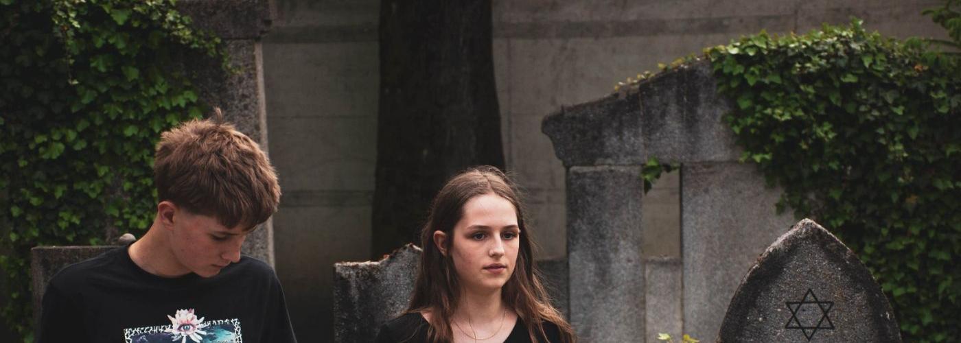 Schüler und Schülerin am jüdischen Friedhof